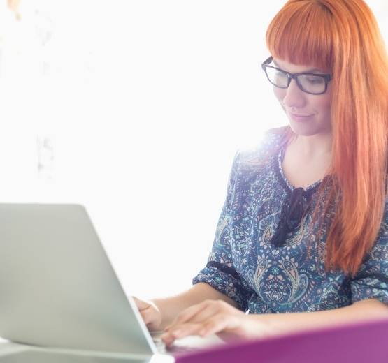 Lady with red hair working on a laptop