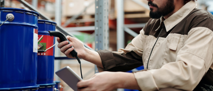 Man using using mobile scanner in a warehouse to ensure the right details are inputted on receipt of a delivery.