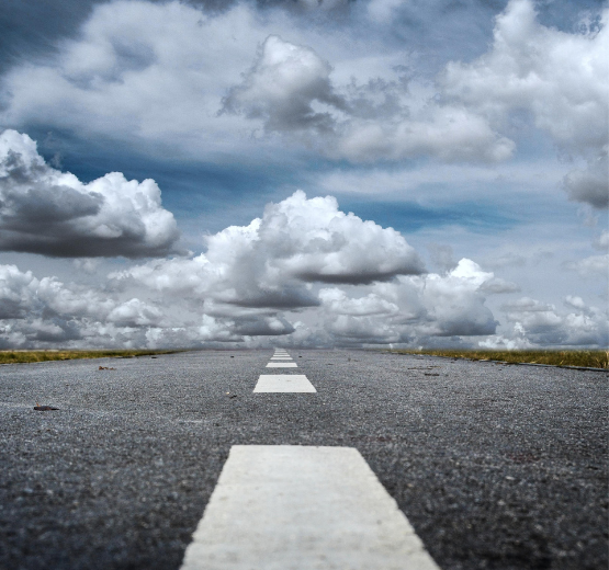 Road with rolling clouds in the sky to represent the journey from on-premise software to a cloud ERP solution.