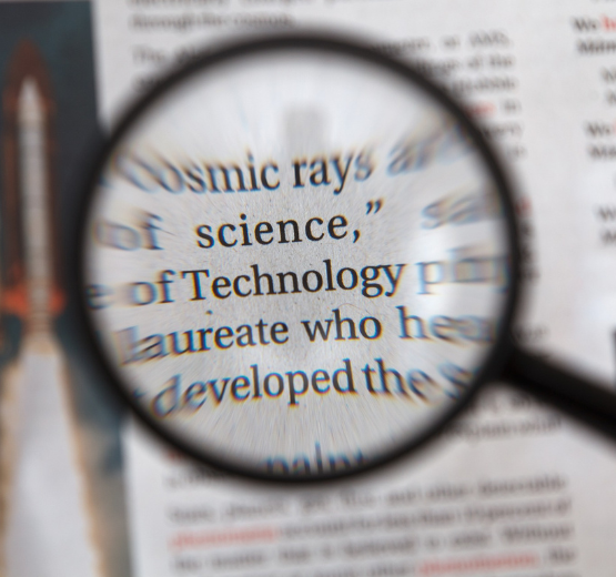 Magnifying glass, highlighting the word technology to denote the Saved Searches functionality in NetSuite cloud ERP, which helps with tracking and reporting.