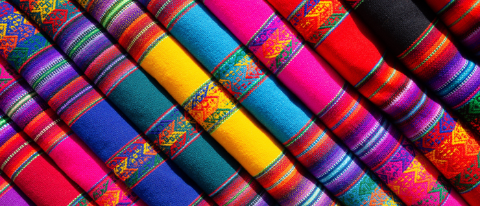 Row of folded colourful fabric to denote owned stock within an outsourced manufacturing process that can be automated in NetSuite. 