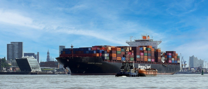 Image of a large container ship at a port bringing in good for retail and whole sale distribution companies struggling to manage supply and inflation.